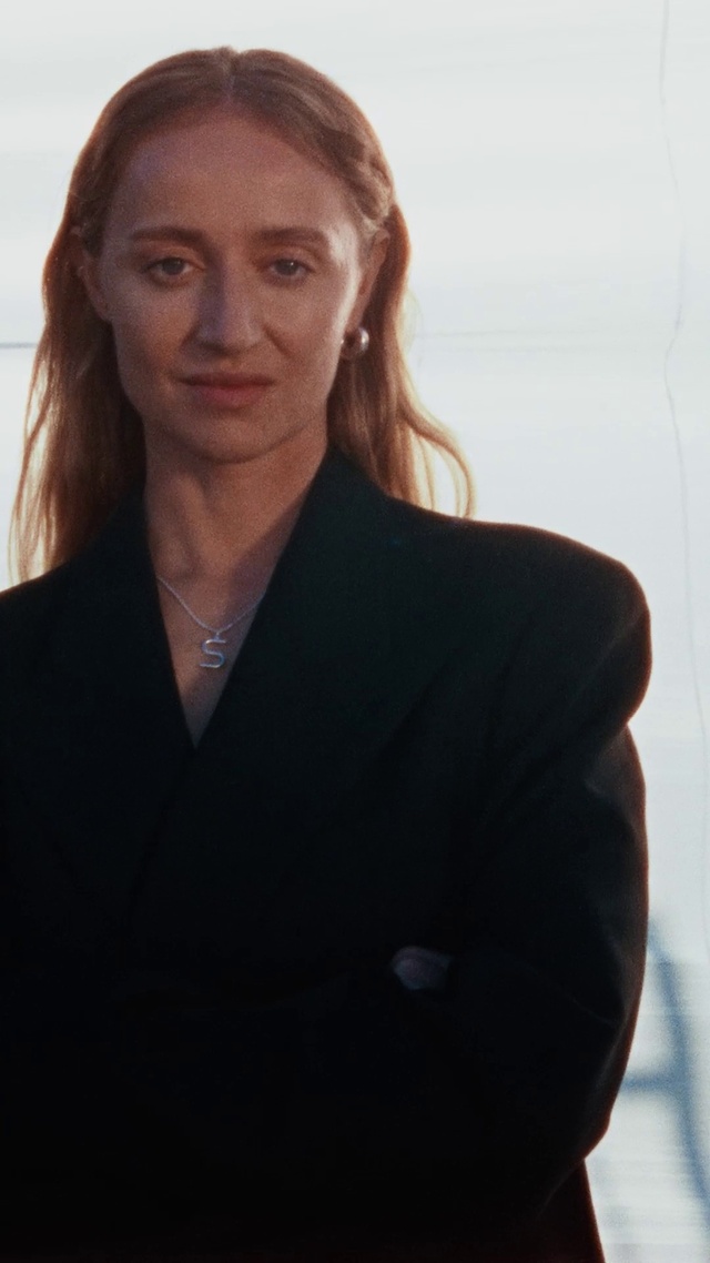 Video Reference: Forehead, Chin, Neck, Sleeve, Gesture, Pantsuit, Collar, Blazer, Formal wear, Throat