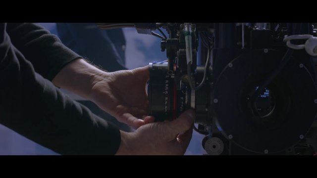 Video Reference: camera, film equipment, lens adjustment, hands, filmmaking, cinematography, production, close-up, camera rig, studio, technical, professional, focus ring, operator