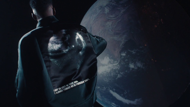 Video Reference: Flash photography, Sleeve, Personal protective equipment, Electric blue, Font, T-shirt, Space, Science, Darkness, Bag