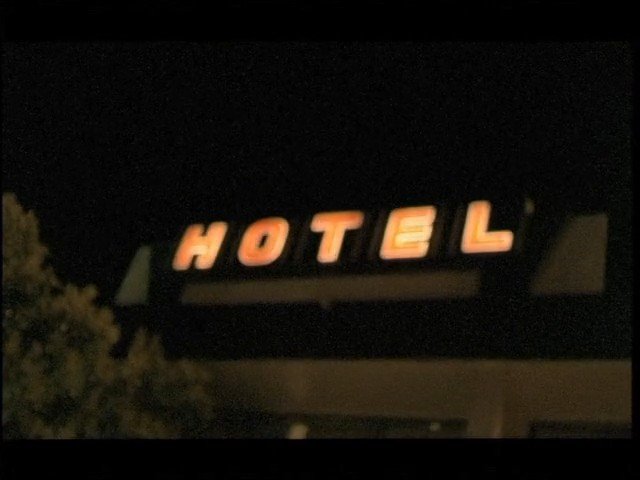 Video Reference: hotel, sign, night, exterior, building, lit, neon, dark, blurred, text, travel, lodging