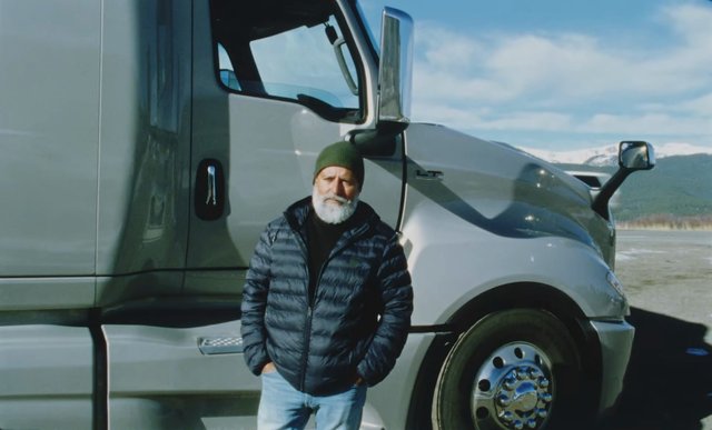 Video Reference: man, semi truck, truck, beanie, bearded, outdoor, road, transportation, vehicle, mountains, sky, winter, portrait, standing, travel, freight