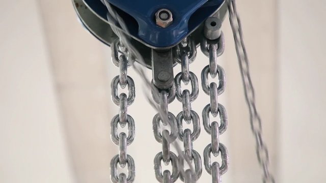 Video Reference: chains, metal, hanging, pulley, hook, mechanism, industrial, close-up, hardware, steel, equipment, motion blur, indoor, ceiling