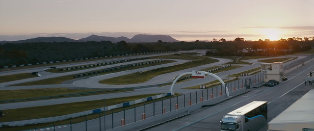 Video Reference: Sky, Vehicle, Car, Race track, Asphalt, Thoroughfare, Landscape, Road, Motor vehicle, Urban design