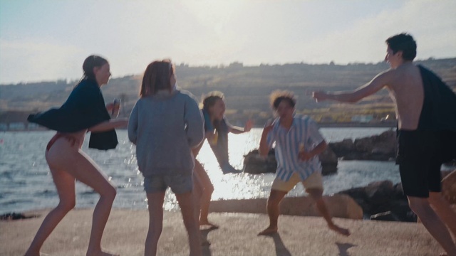 Video Reference: Sky, Shorts, Water, People on beach, Natural environment, Happy, Standing, Gesture, Bermuda shorts, Body of water