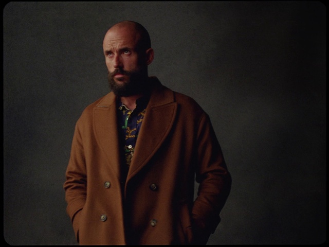 Video Reference: Chin, Beard, Neck, Sleeve, Dress shirt, Gesture, Collar, Grey, Facial hair, Audio equipment