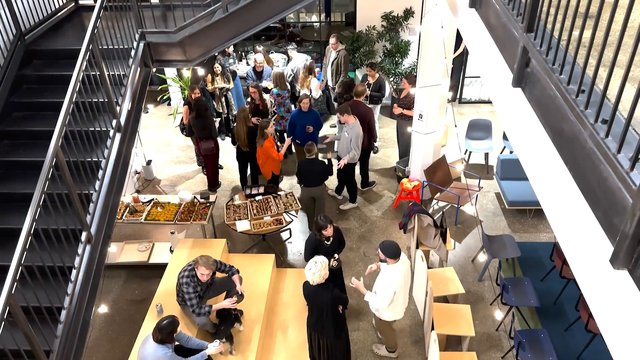Video Reference: indoor, social event, gathering, people, conversation, atrium, modern interior, buffet, catering, networking, stairs, tables, chairs, office, lobby, crowd