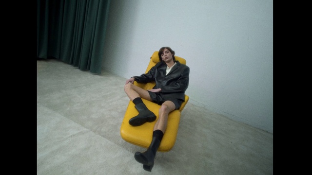 Video Reference: Comfort, Flash photography, Curtain, Knee, Grey, Thigh, Automotive design, Black hair, Flooring, Chair