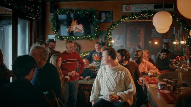 Video Reference: bar, people, group, socializing, holiday decor, festive, interior, drinks, pub, conversation, celebration, warm lighting, counter, casual, friends