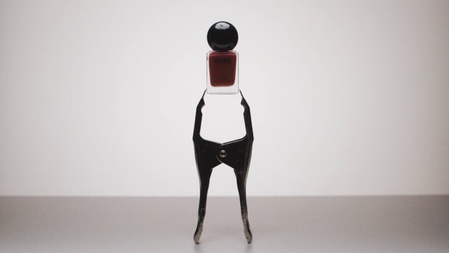 Video Reference: nail polish, cosmetic bottle, clamp, product shot, studio background, minimal, still life, beauty, container, black clip, red liquid, isolated, centered, simple composition