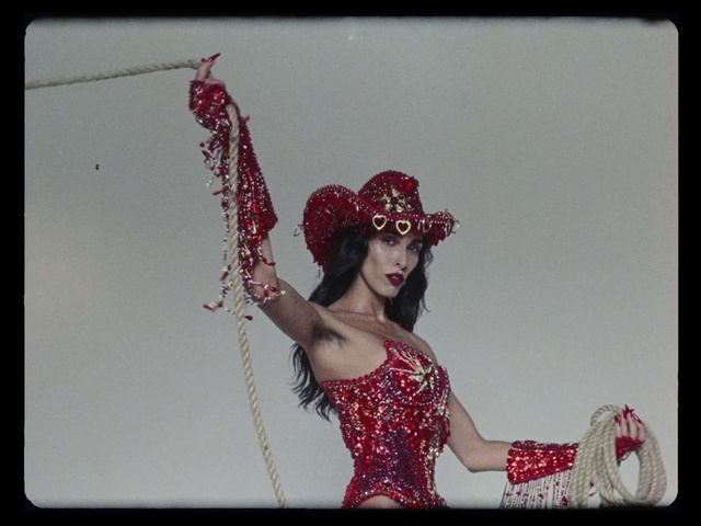 Video Reference: Flash photography, Sleeve, Eyelash, Gesture, Fashion design, Headpiece, Rectangle, Magenta, Lipstick, Waist