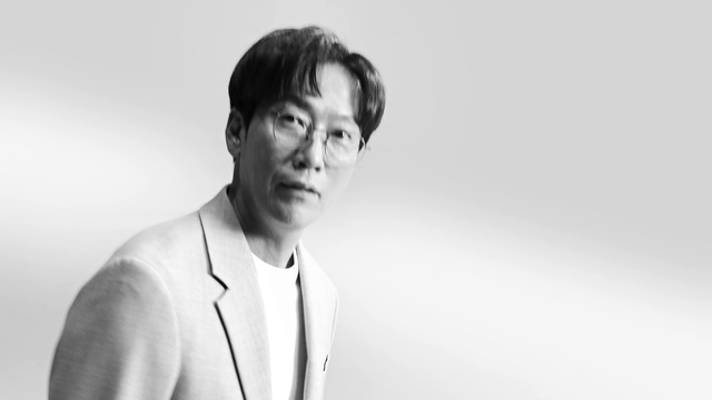 Video Reference: Outerwear, Shoulder, Neck, Flash photography, Jaw, Dress shirt, Sleeve, Gesture, Eyewear, Blazer