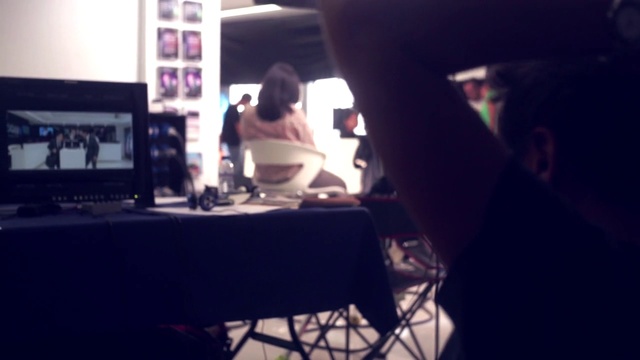 Video Reference: Table, Eyewear, Desk, Audio equipment, Hat, Computer monitor, Event, Fun, Job, T-shirt