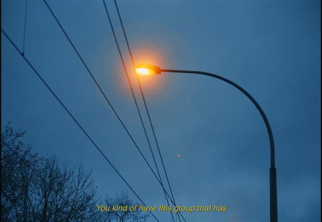 Video Reference: streetlight, evening, blue sky, power lines, trees, urban, outdoors, night, glow, silhouette, subtitles, sky
