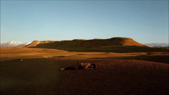 Video Reference: desert, landscape, person, lying down, barren, hills, sunset, outdoors, remote, wilderness, sky, solitude