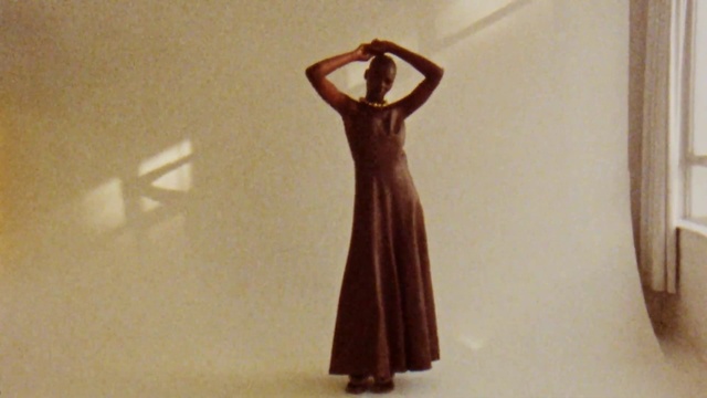 Video Reference: One-piece garment, Dress, Neck, Sleeve, Wood, Gesture, Religious item, Waist, Toy, Sculpture