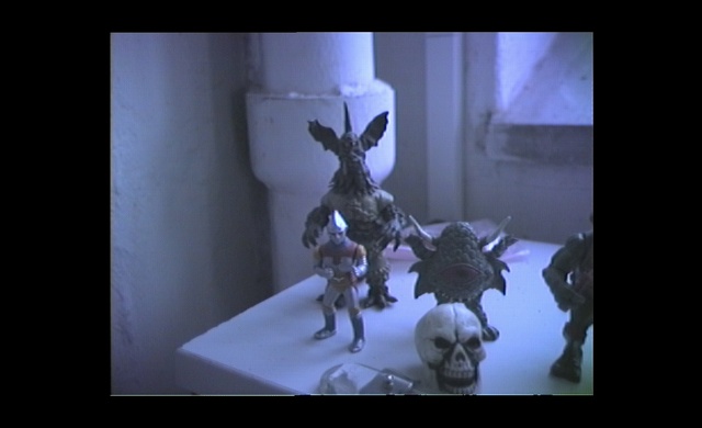 Video Reference: Purple, Art, Sculpture, Darkness, Toy, Event, Fictional character, Electric blue, Visual arts, Room