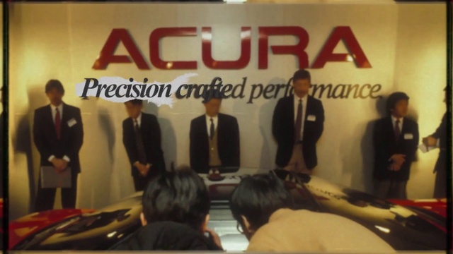 Video Reference: Coat, Suit, Tie, Font, Blazer, Chair, Public speaking, Event, Stage equipment, Formal wear