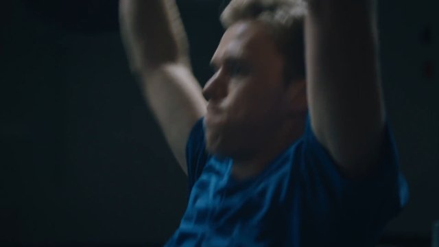 Video Reference: person, close-up, raised arms, blue shirt, dark background, motion blur, indoor, fitness, exercise, stretching, portrait, sports