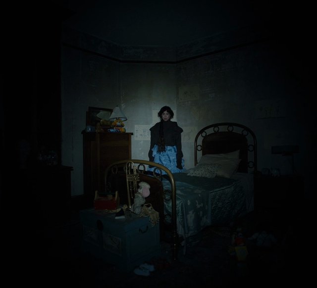 Video Reference: bedroom, person, low light, dark, vignette, bed, indoor, standing, nighttime, furniture, messy room, flashlight, moody, gothic, portrait, interior