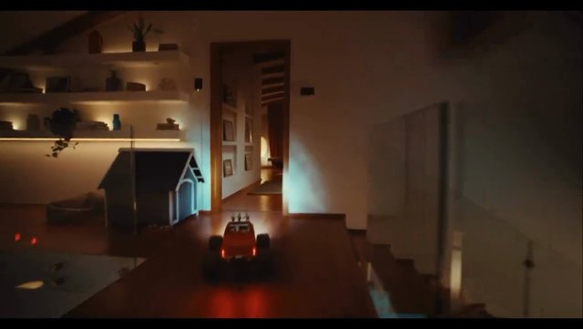 Video Reference: remote control car, toy car, indoor, hallway, home interior, night, motion, small vehicle, wood floor, shelves, doorway, playroom, low light, perspective, lifestyle