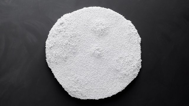 Video Reference: white powder, granules, mound, pile, dark background, close-up, top view, texture, abstract, material, ingredient, surface
