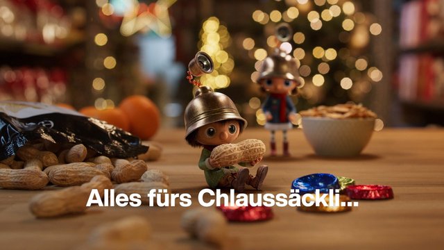Video Reference: toy figures, peanuts, candy, holiday lights, festive, tabletop, shallow depth of field, bokeh, wrapped sweets, christmas, seasonal, text overlay, miniature, snack, indoor scene