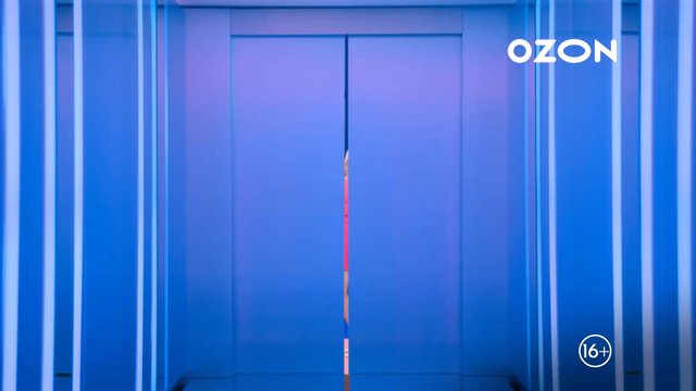 Video Reference: elevator, doors, blue lighting, interior, partially hidden person, gap, studio set, logo, text, age rating, commercial, advertisement