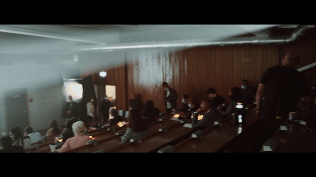 Video Reference: Event, Entertainment, Crowd, Darkness, Chair, Musical instrument accessory, Room, Audience, Conference hall, Ceiling