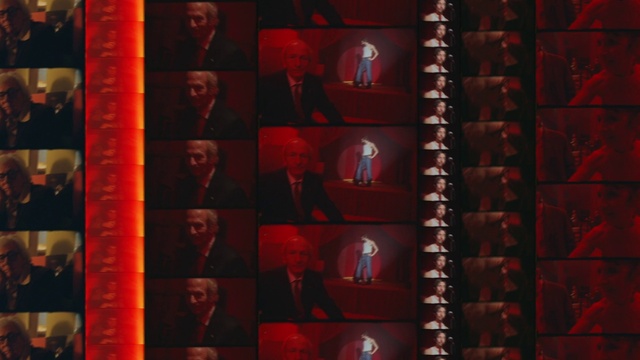 Video Reference: Font, Red, Suit, Art, Tie, Event, Carmine, Collection, Room, Visual arts
