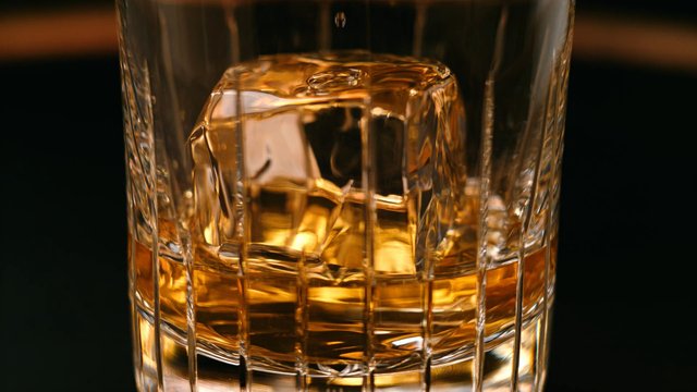 Video Reference: glass, drink, whiskey, ice, amber liquid, close-up, beverage, bar, cocktail, refreshment, transparent, dark background