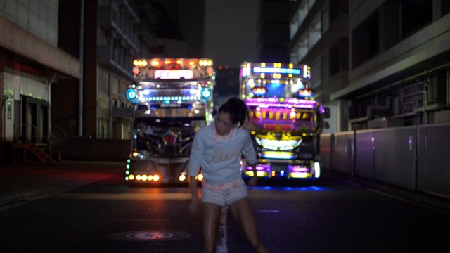 Video Reference: night, street, person, truck, decorated trucks, colorful lights, vehicle lights, urban, dark, motion blur, road, outdoor, nighttime, transportation