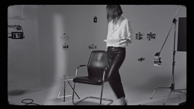Video Reference: Arm, Shoulder, Flash photography, Chair, Black-and-white, Style, Flooring, Knee, Elbow, Font