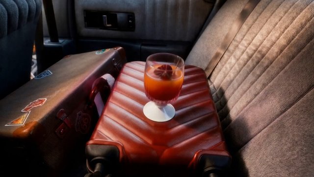 Video Reference: drink, glass, cocktail, suitcase, luggage, car interior, travel, seat, red, close-up, still life, vehicle