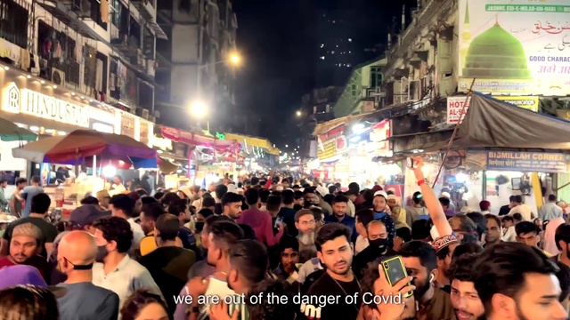 Video Reference: Photograph, Light, Building, Sky, Hat, Crowd, Public space, City, Market, Metropolitan area