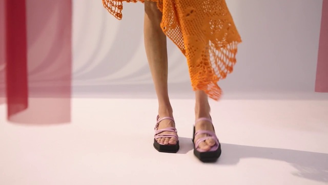 Video Reference: Clothing, Human body, Dress, Orange, Nail, Flooring, Thigh, Knee, Fashion design, Sandal