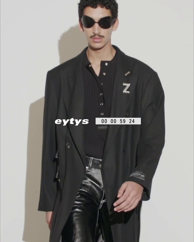 Video Reference: Face, Outerwear, Black, Fashion, Neck, Sleeve, Street fashion, Waist, Dress shirt, Eyewear