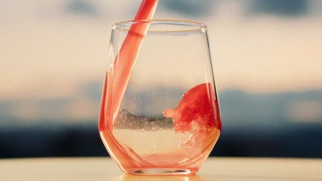 Video Reference: wine glass, pouring, red liquid, beverage, close-up, swirl, glassware, drink, motion, liquid, blurred background, tabletop, refreshment