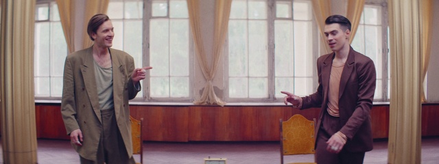 Video Reference: Outerwear, Gesture, Interior design, Blazer, Curtain, White-collar worker, Event, Formal wear, Suit, Conversation