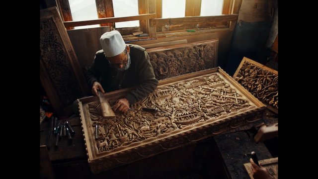 Video Reference: woodcarving, artisan, craftsmanship, workshop, elderly man, hand tools, ornate carving, woodwork, traditional craft, handmade, interior, labor, close-up, decorative panel
