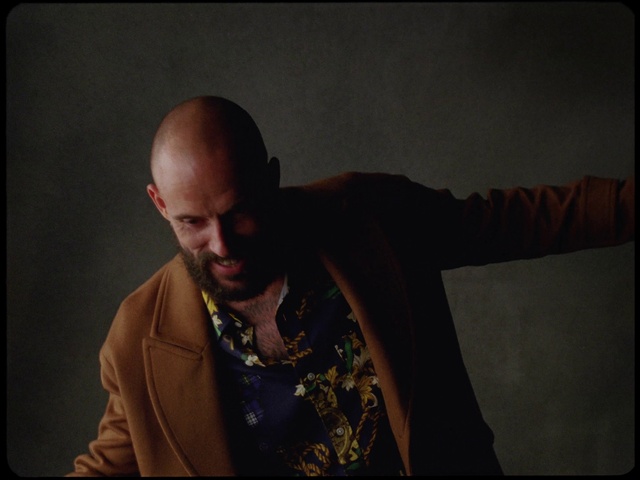 Video Reference: Flash photography, Beard, Adaptation, T-shirt, Audio equipment, Jewellery, Facial hair, Event, Room, Sitting