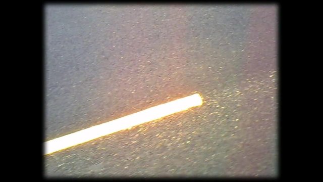 Video Reference: abstract, close-up, diagonal, white strip, glowing, grainy, surface, texture, minimal, dark background, line, blurred, out of focus