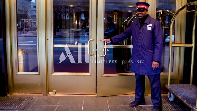 Video Reference: Hat, Fixture, Door, Sleeve, Building, Street fashion, Cap, Blazer, Baseball cap, Formal wear