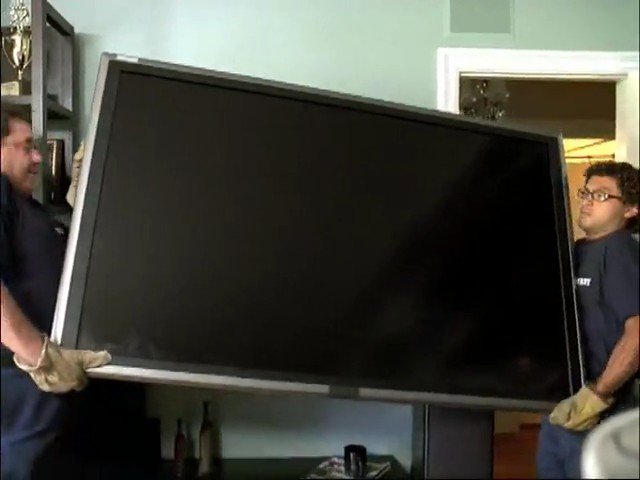 Video Reference: people, carrying, television, flat screen, indoor, doorway, moving, gloves, equipment, home, large object, transport