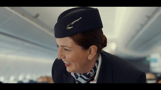 Video Reference: Cap, Smile, Flash photography, Gesture, Flight attendant, Street fashion, Headgear, Baseball cap, Suit, Microphone