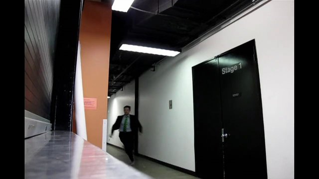 Video Reference: hallway, corridor, indoor, stage door, office, backstage, man, suit, tie, walking, interior, door, commercial building, motion blur