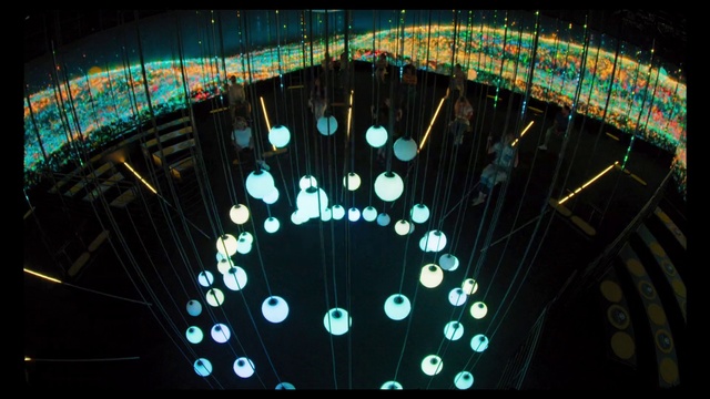 Video Reference: Circle, Symmetry, Glass, Electric blue, Pattern, Technology, Font, Space, Event, Darkness