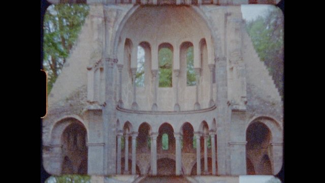 Video Reference: architecture, stone building, arches, columns, facade, historic, ornate, ruins, outdoors, trees, symmetry, old film, grainy, structure, classical, monument
