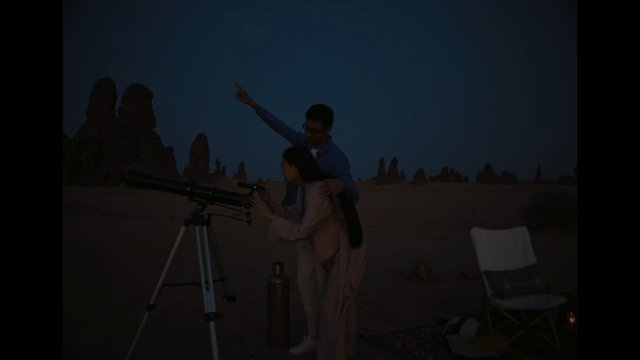 Video Reference: telescope, astronomy, stargazing, desert, night, couple, outdoors, travel, landscape, rock formations, camping, silhouette, science, adventure