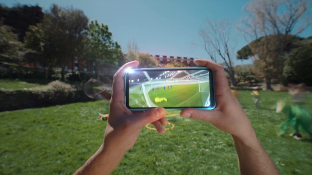 Video Reference: Hand, Plant, Sky, Tree, Handheld game console, Outdoor recreation, Natural landscape, Gadget, Grassland, Grass