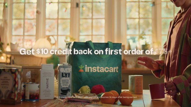 Video Reference: kitchen, grocery bag, shopping, groceries, packaged food, promotion, advertisement, instacart, table, sunlight, window, mug, person, oat milk, body wash, home